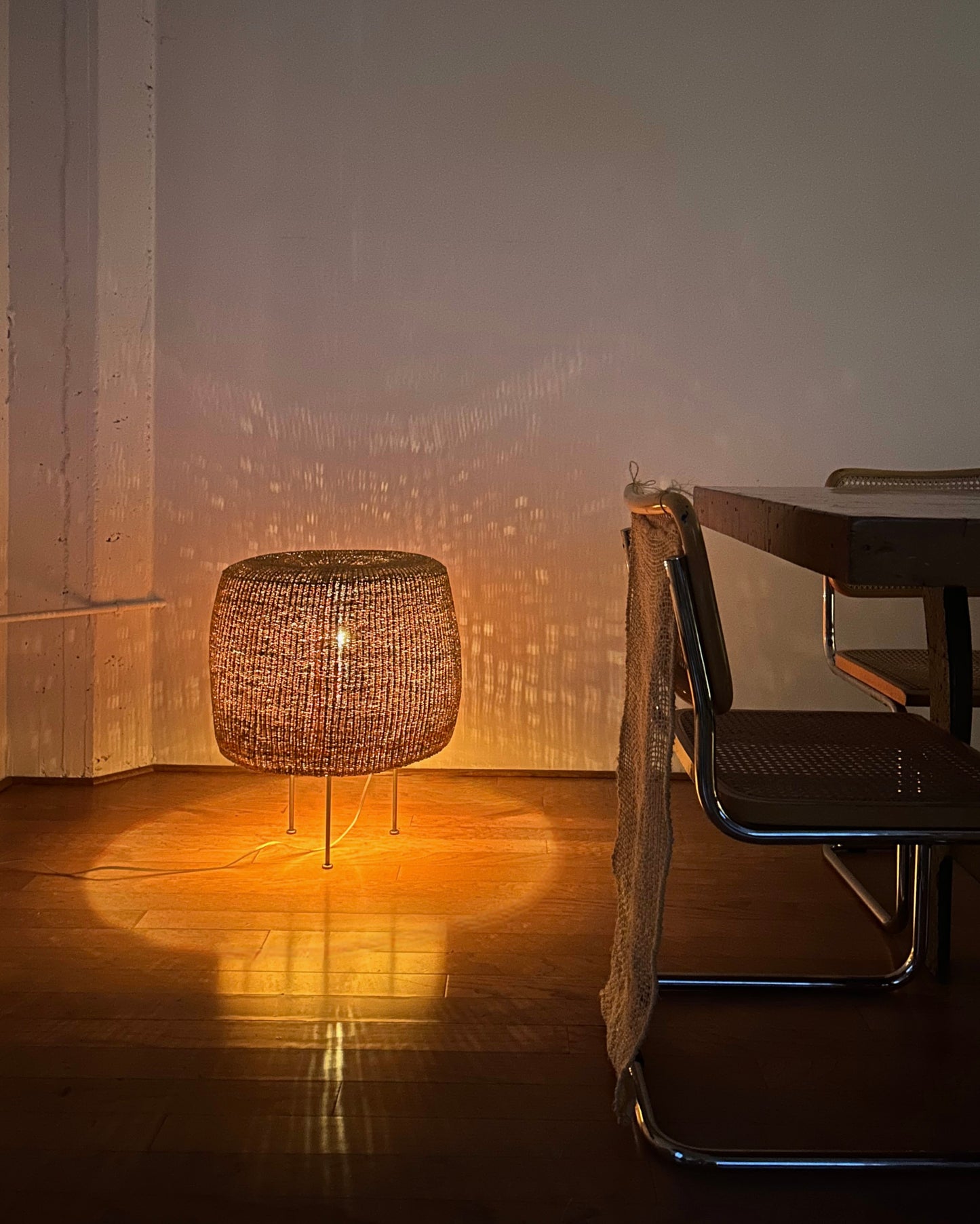 Woven floor lamp at night with a soft warm glow