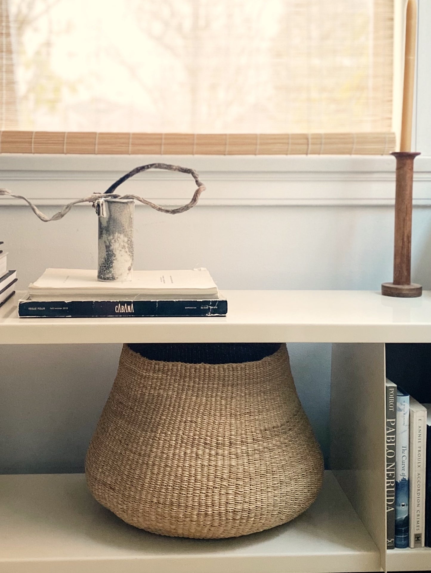 Small handwoven basket on a shelf,  made from natural colored elephant grass, Ghana.