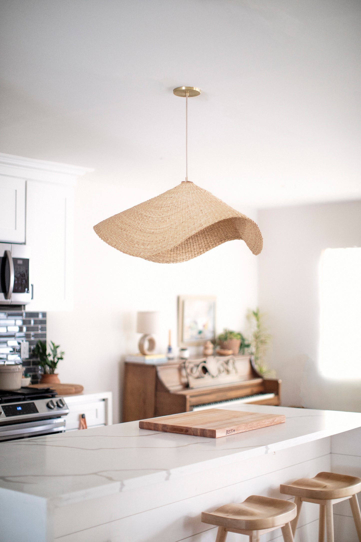 The Landslide pendant lights are made with natural colored, sustainable elephant grass in northern Ghana. Hand woven as a shallow cone and shaped into undulating waves, these lights are beautiful in bedrooms as well as living spaces.