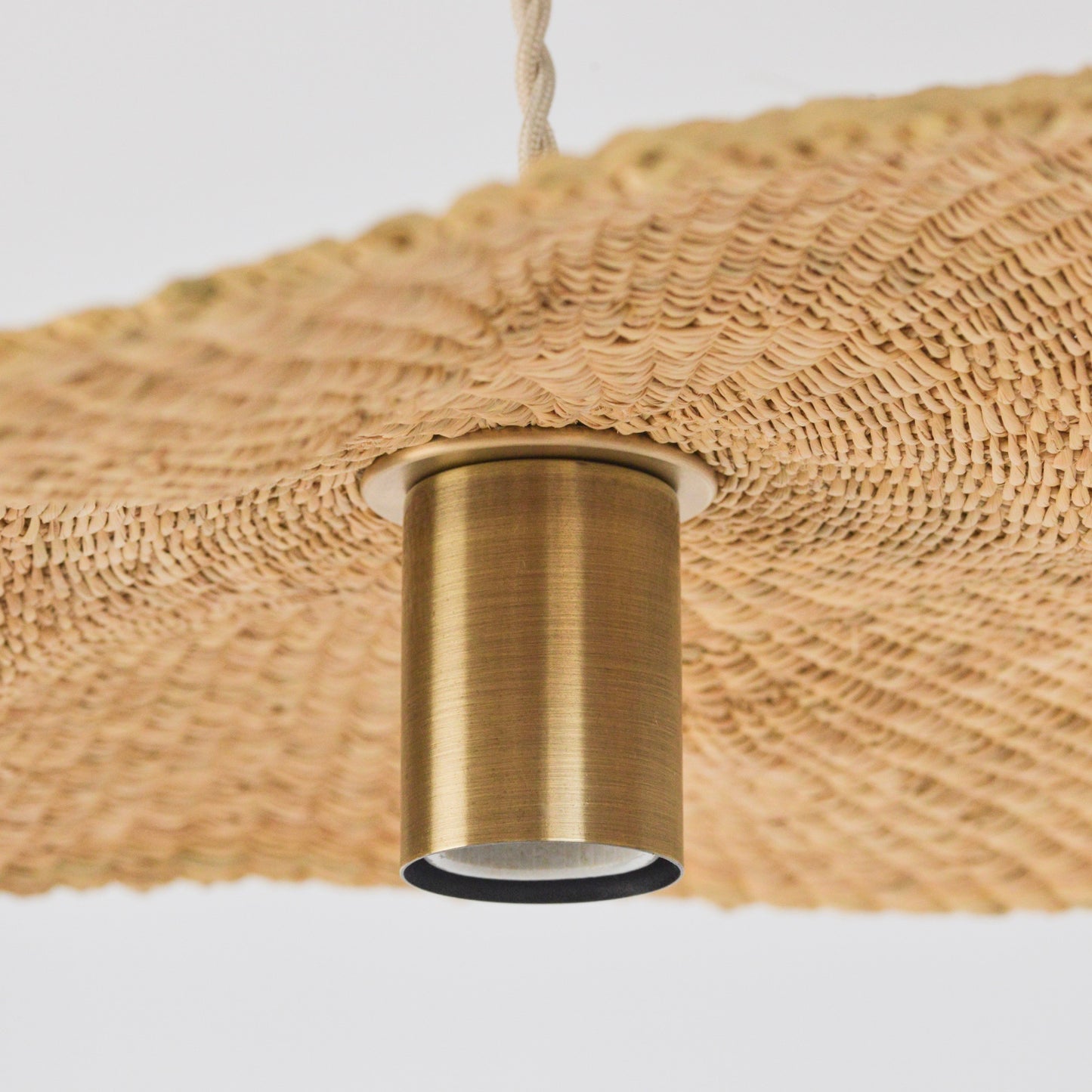 Showing the inside, hand woven texture of the Sunhat pendant light, and its pendant lighting fixture.
