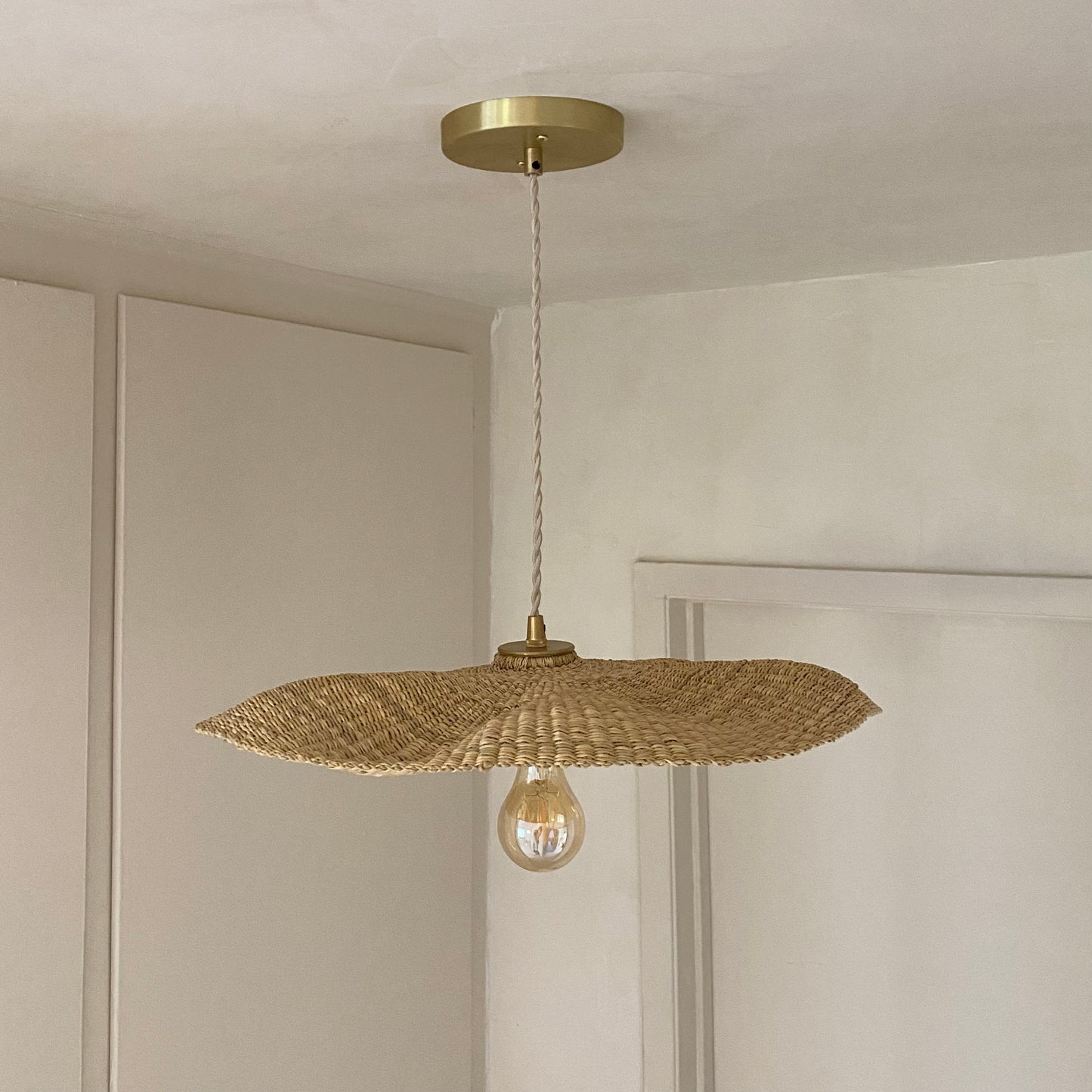 Our Fawn pendant lights are handwoven from natural colored elephant grass in northern Ghana. Their wide and floating shape is striking in any living space, especially over a dining table or kitchen island.