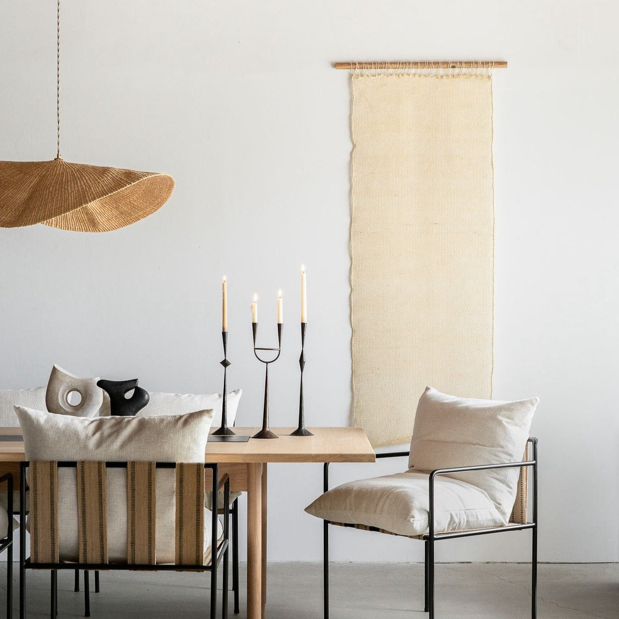 A wall hanging in a dining room. Our Cortina Puerta is a sheer handwoven textile hanging, made in Oaxaca, Mexico, from the leftover maguey leaves from mezcal production.