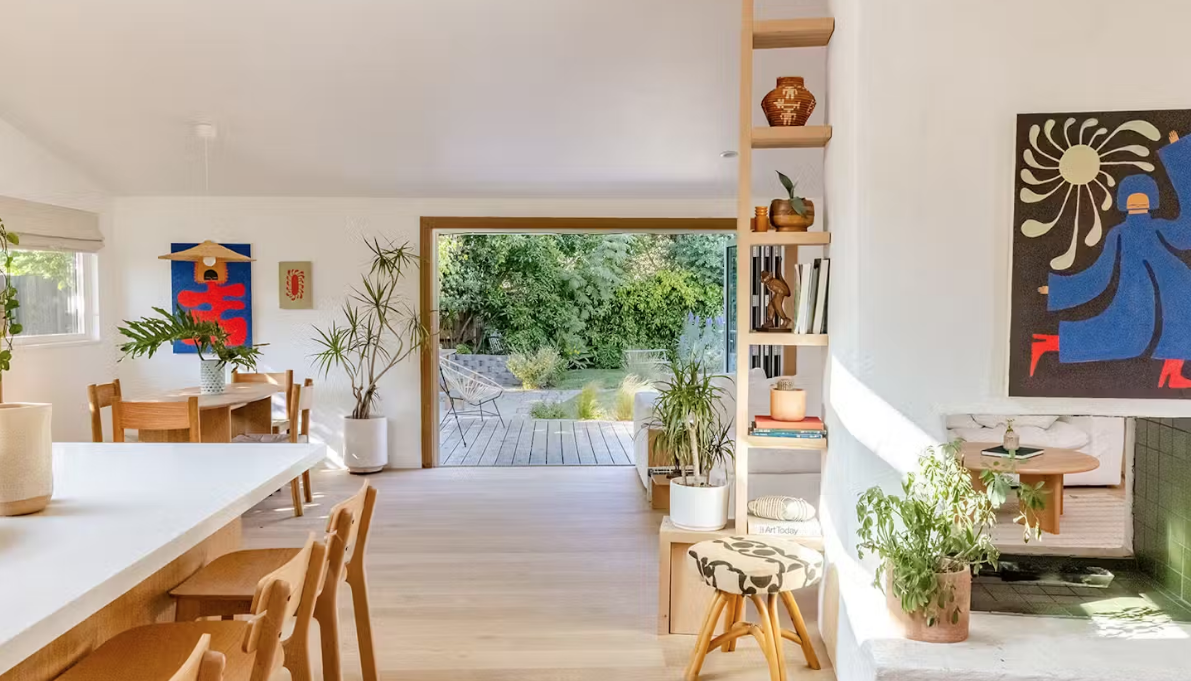 Beautiful living space with dining table, leading into a garden.