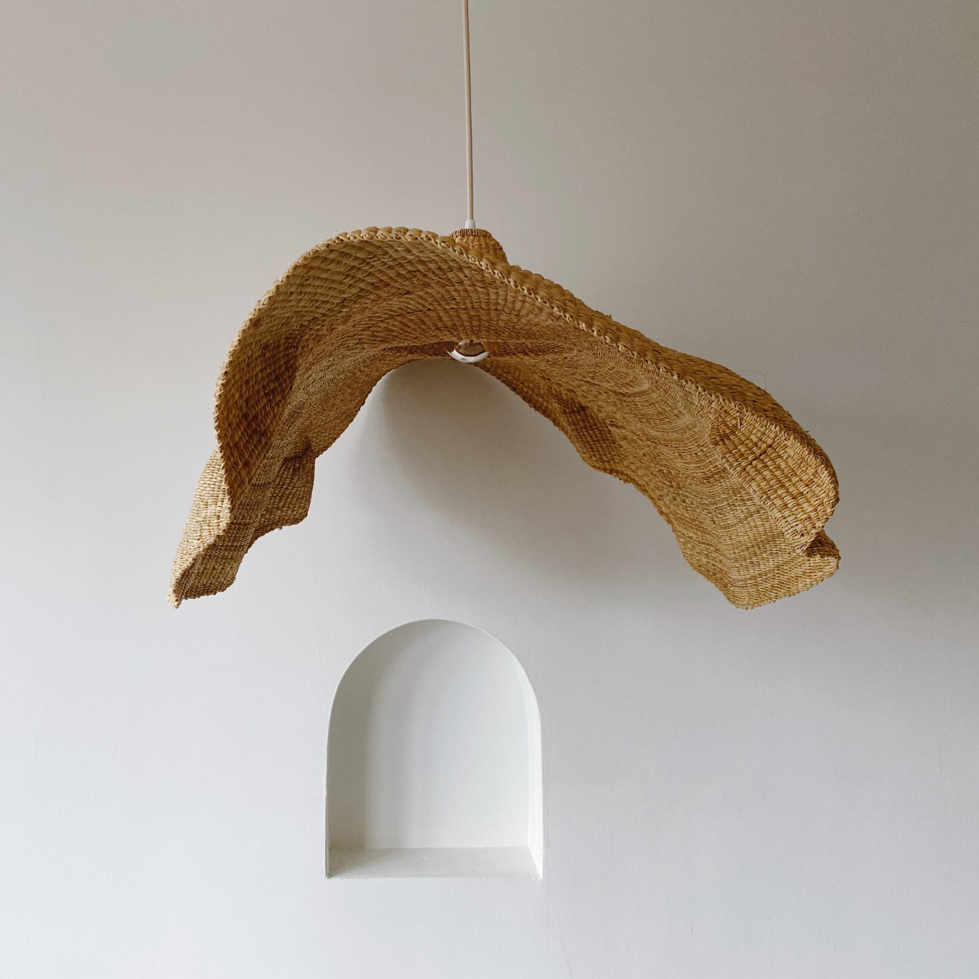Peaked Fawn light shade, handwoven from sustainable elephant grass in Ghana. Their wide and floating shape are striking in any living space, especially in bedrooms or over dining tables.