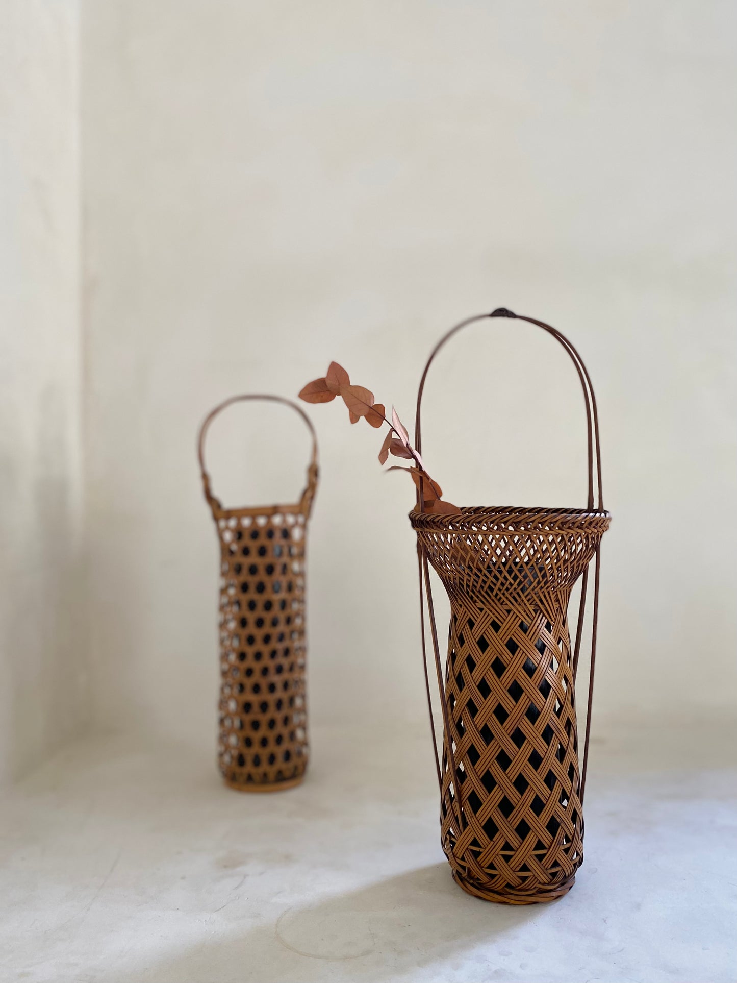 Two vintage Japanese Ikebana (flower arrangement) baskets with handles. Woven by hand in Japan from caramel colored bamboo. Circa 1950.