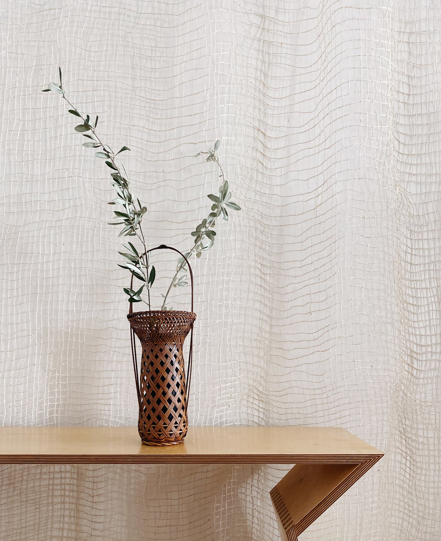 A vintage Japanese Ikebana (flower arrangement) basket with handle. Woven by hand in Japan from caramel colored bamboo. Circa 1950.