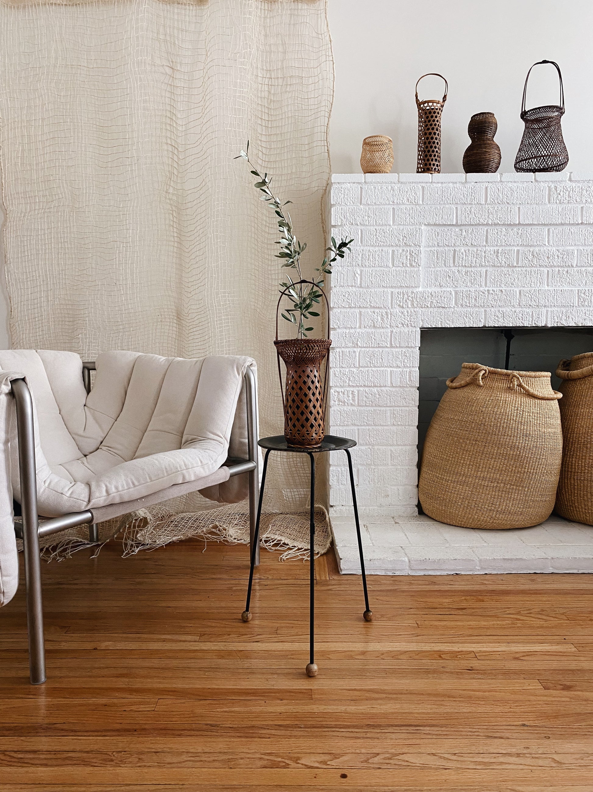 Many vintage Japanese Ikebana (flower arrangement) baskets shown in a sitting room with fire place. Woven by hand in Japan from caramel colored bamboo. Circa 1950.