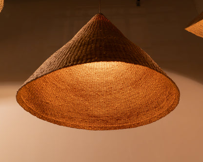 Woven pendant light with a warm glow on a neutral background