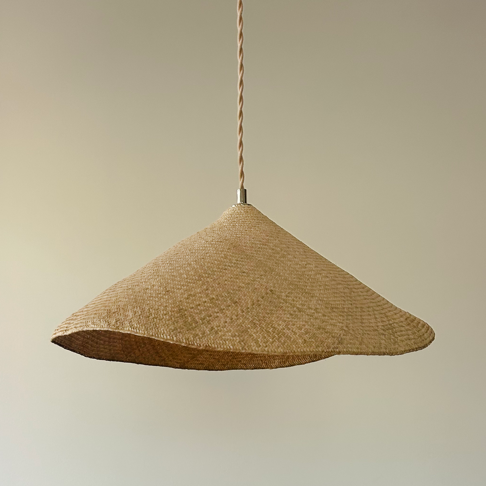 Woven pendant light hanging above a dining table
