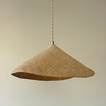 Woven pendant light hanging above a dining table