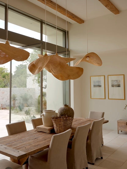 Group of Peaked Fawn pendant lights over dining table, handwoven elephant grass with peaked crown, SWOPA women artisans northern Ghana