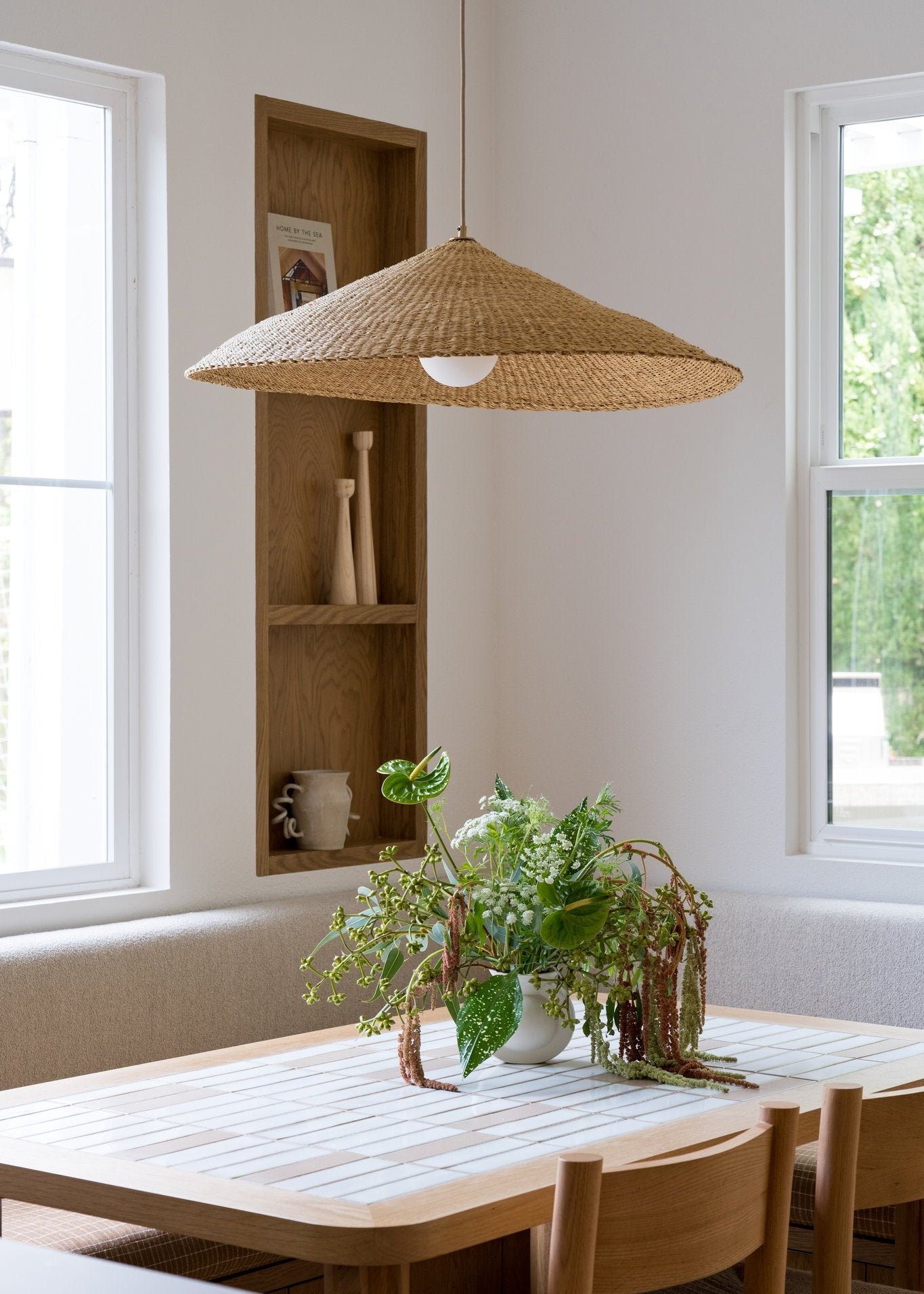 Dining room with woven pendant light over kitchen table.