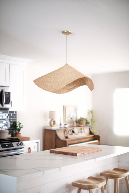The Landslide pendant lights are made with natural colored, sustainable elephant grass in northern Ghana. Hand woven as a shallow cone and shaped into undulating waves, these lights are beautiful in bedrooms as well as living spaces.