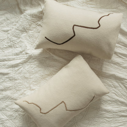 Two cream rectangular cushions with brown squiggle lines.