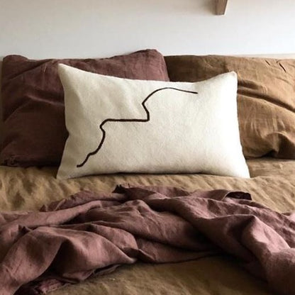 Cream rectangular cushion with black squiggle line.