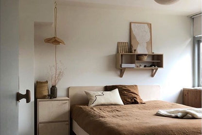 Cream rectangular cushion with black squiggle line on a bed.
