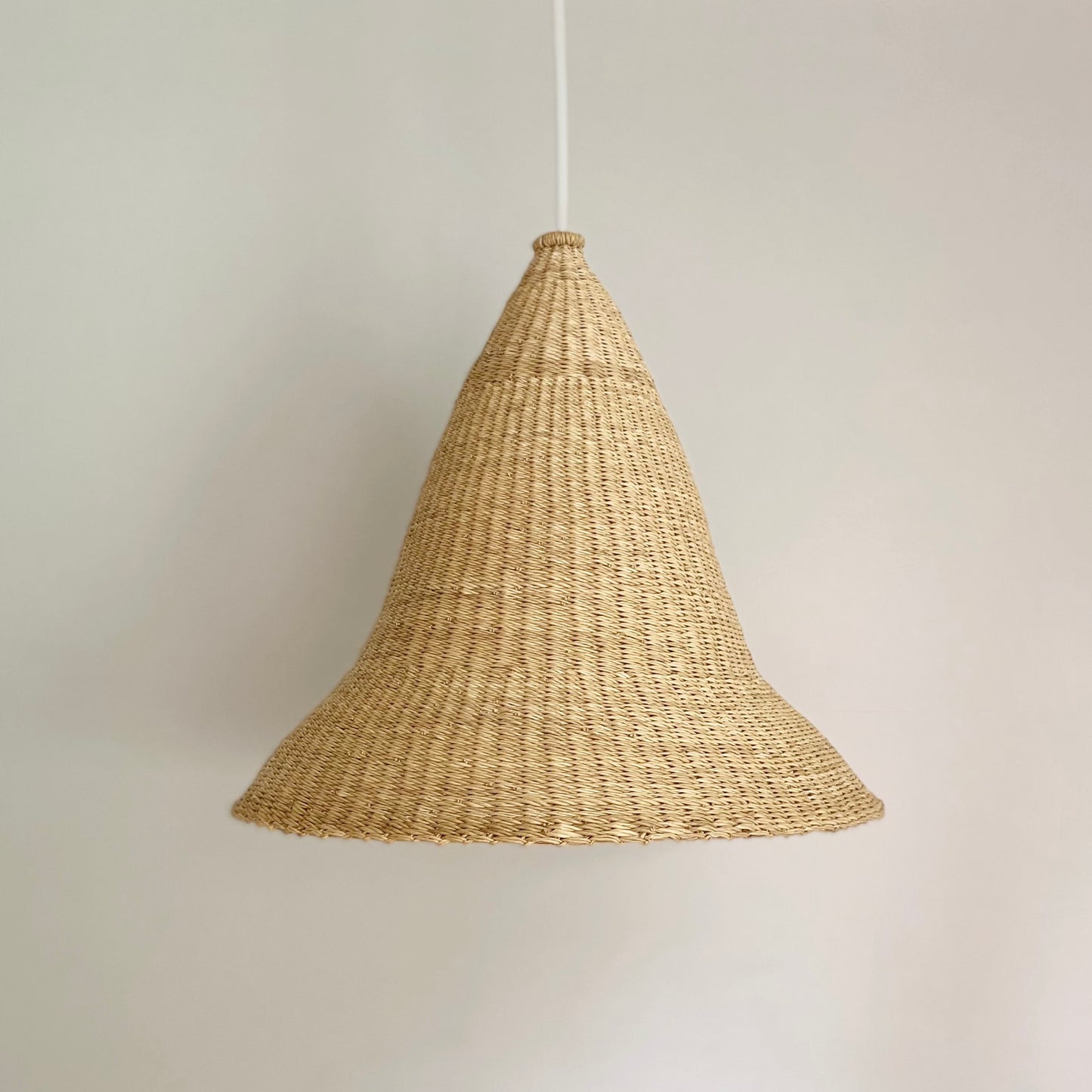 Witches Hat light shade is handwoven from sustainable materials in Ghana. Their steep cone shape casts a downward light, ideal for spaces that call for a more direct light source.