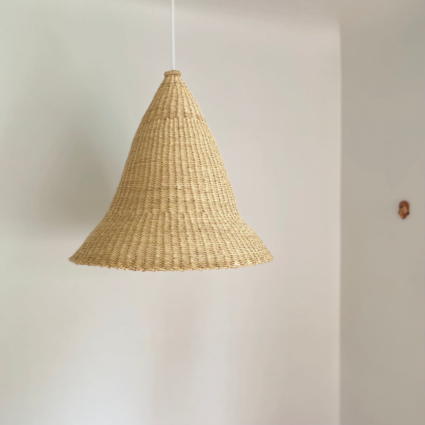 Witches Hat light shade is handwoven from sustainable materials in Ghana. They are a steep cone shape. Their steep cone shape casts a downward light, ideal for spaces that call for a more direct light source.