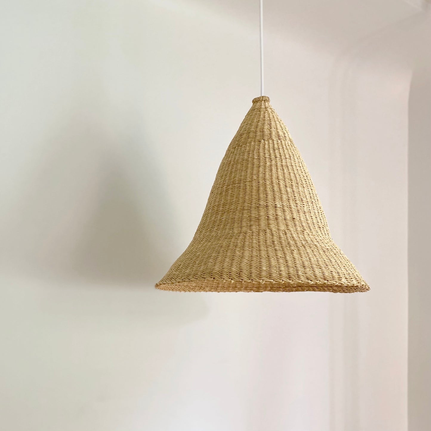 Witches Hat light shade is handwoven from sustainable materials in Ghana. Their steep cone shape casts a downward light, ideal for spaces that call for a more direct light source.