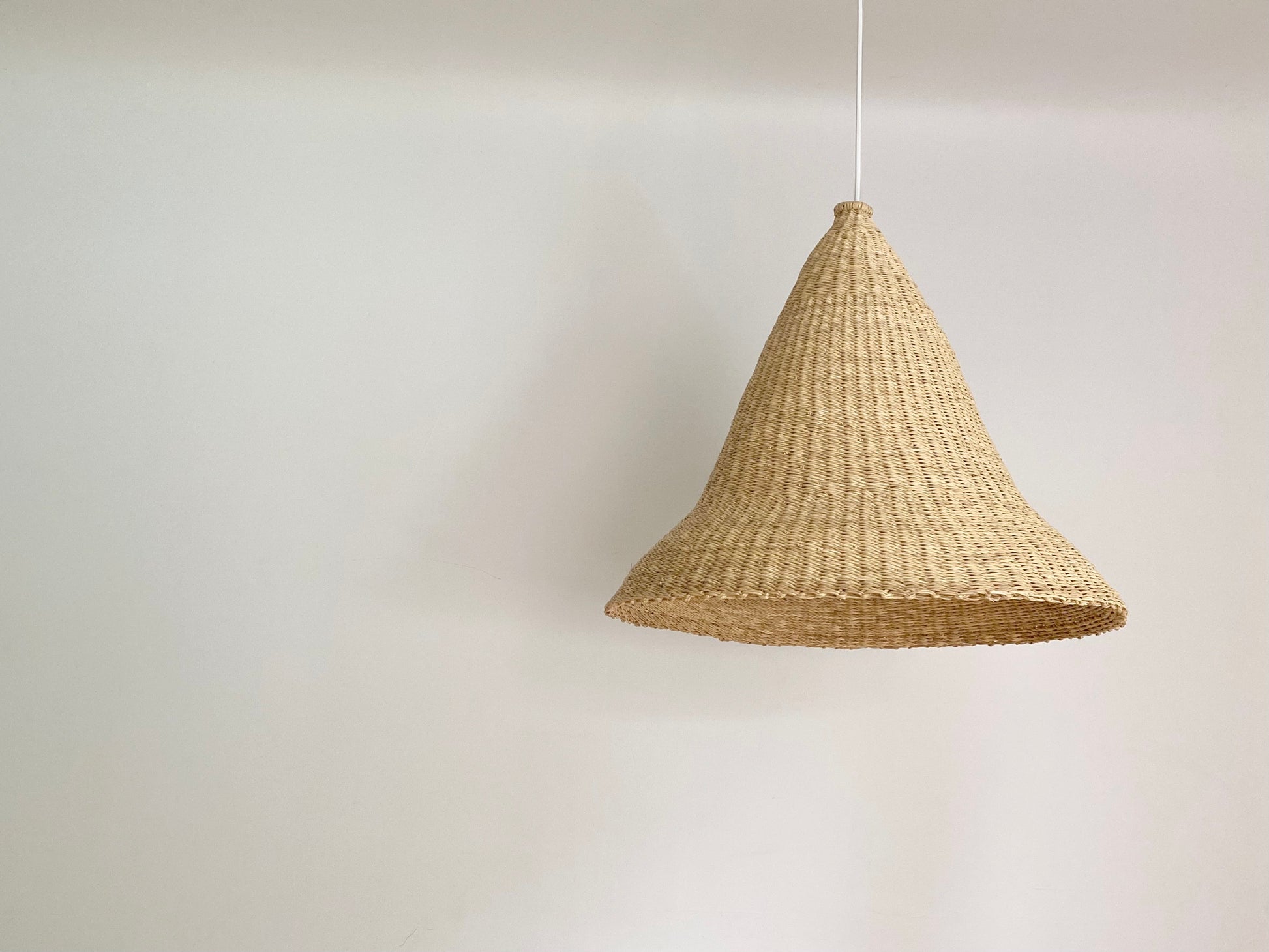 Witches Hat light shade is handwoven from sustainable materials in Ghana. Their steep cone shape casts a downward light, ideal for spaces that call for a more direct light source.