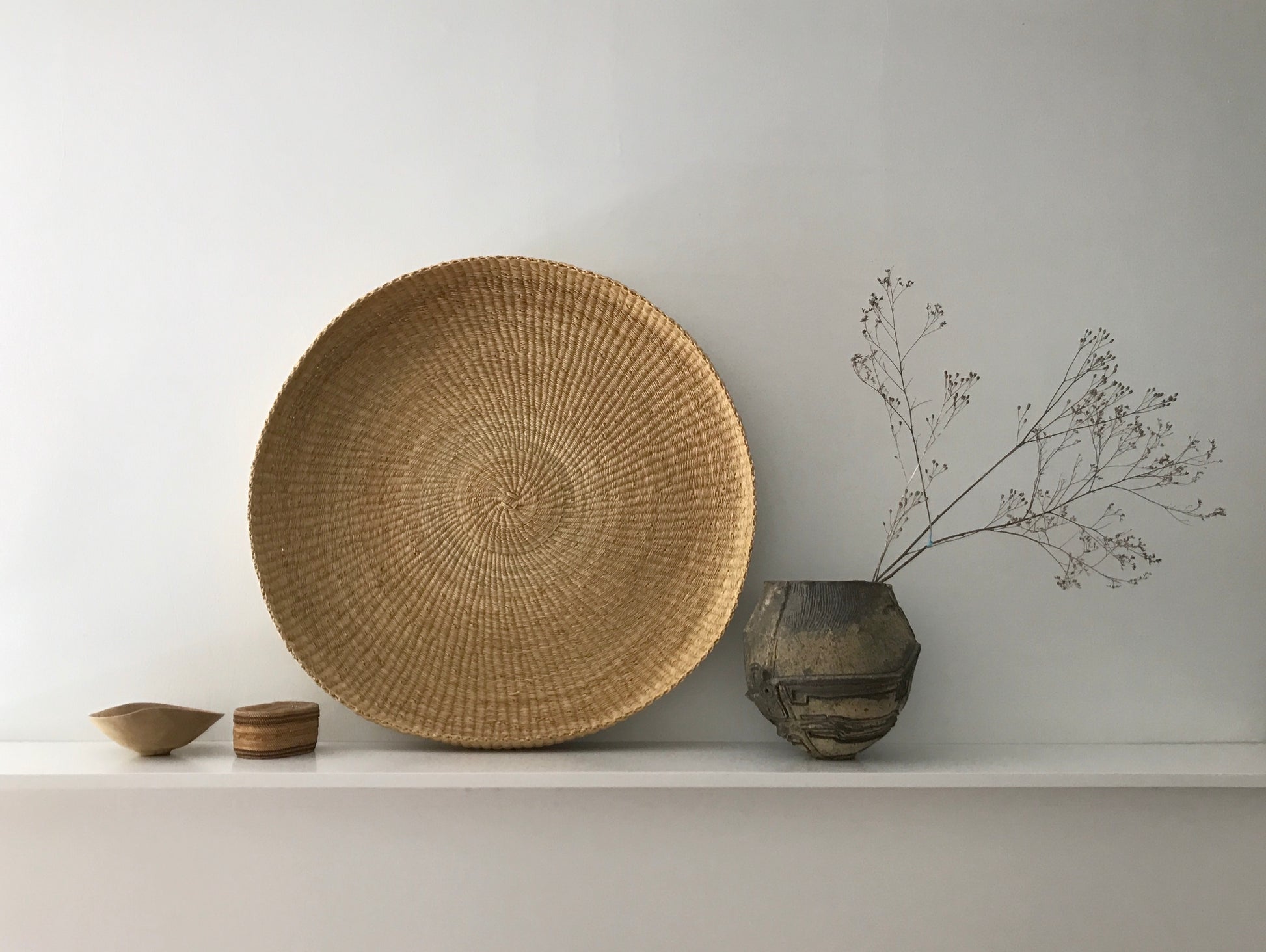 Handwoven round tray made from sustainable natural grass in Ghana.